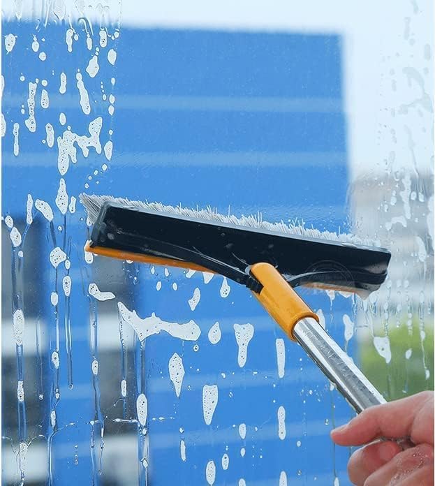 Person using a squeegee to clean a window with a blue background
