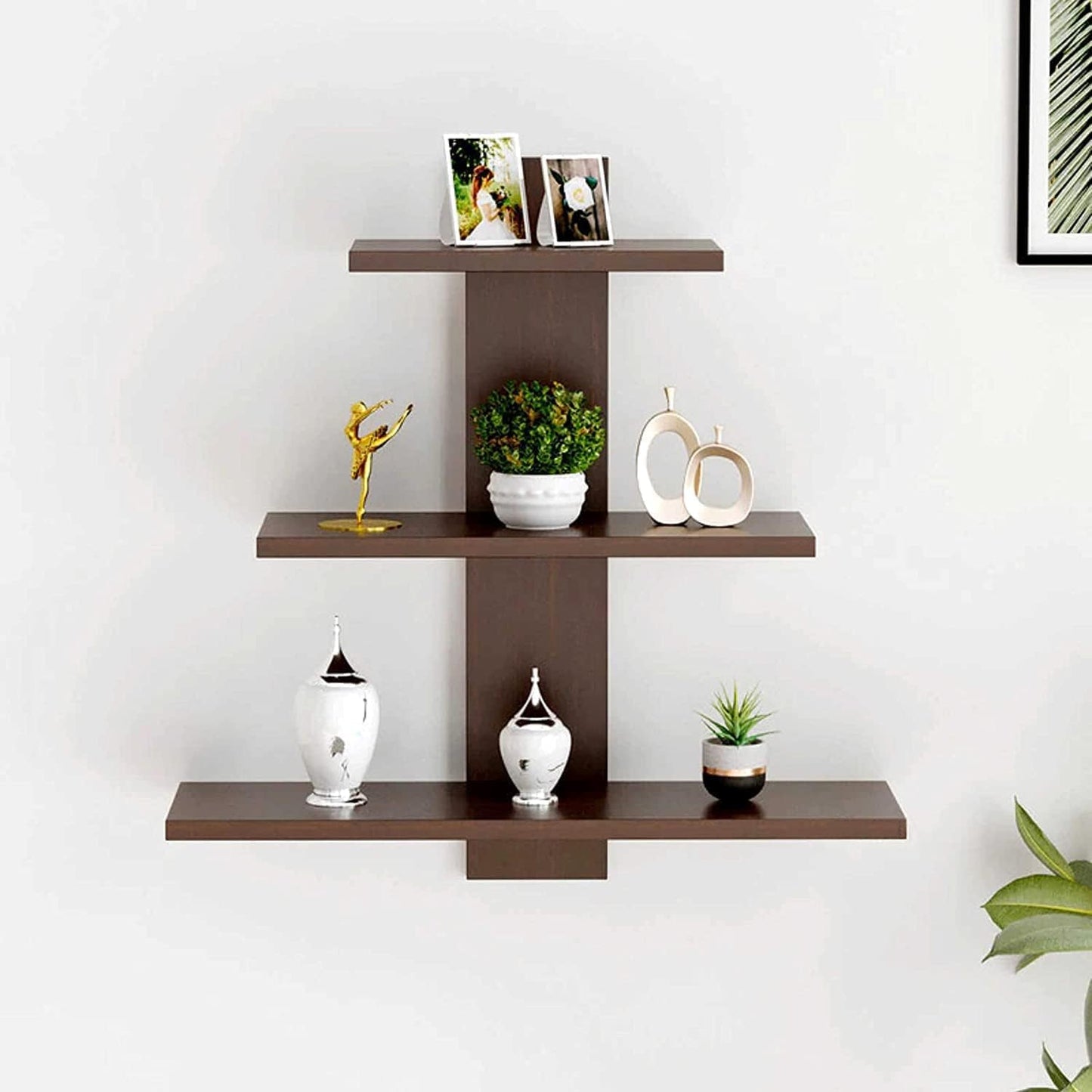 Wall-mounted brown shelf with decorative items against a white wall