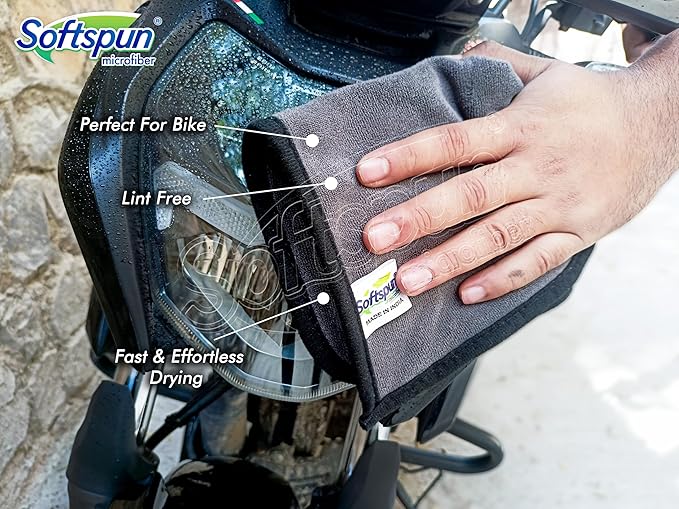 Person cleaning a bike headlight with a Softspun microfiber cloth.